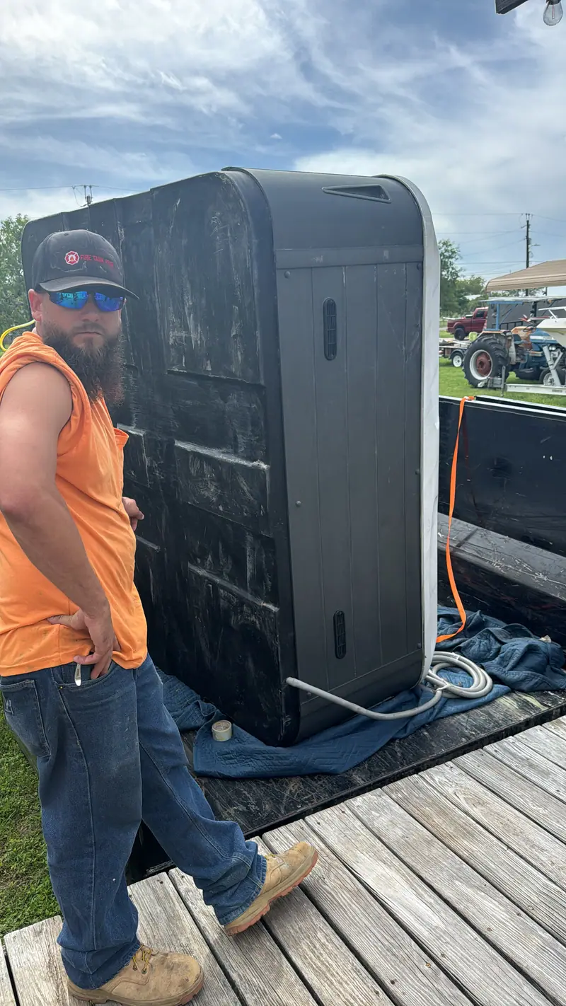 Hot tub shell loaded on the dump trailer with moving blankets underneath