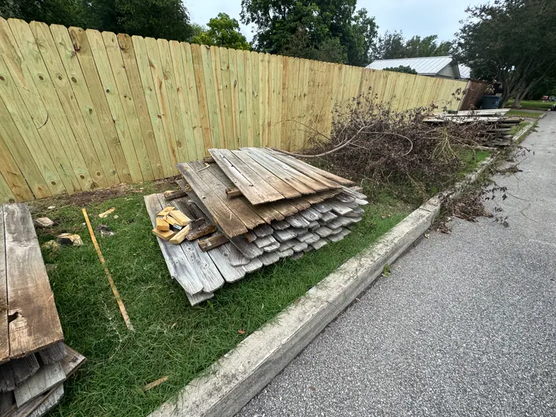 Pile of old fence pickets and brush at the curb in New Braunfels