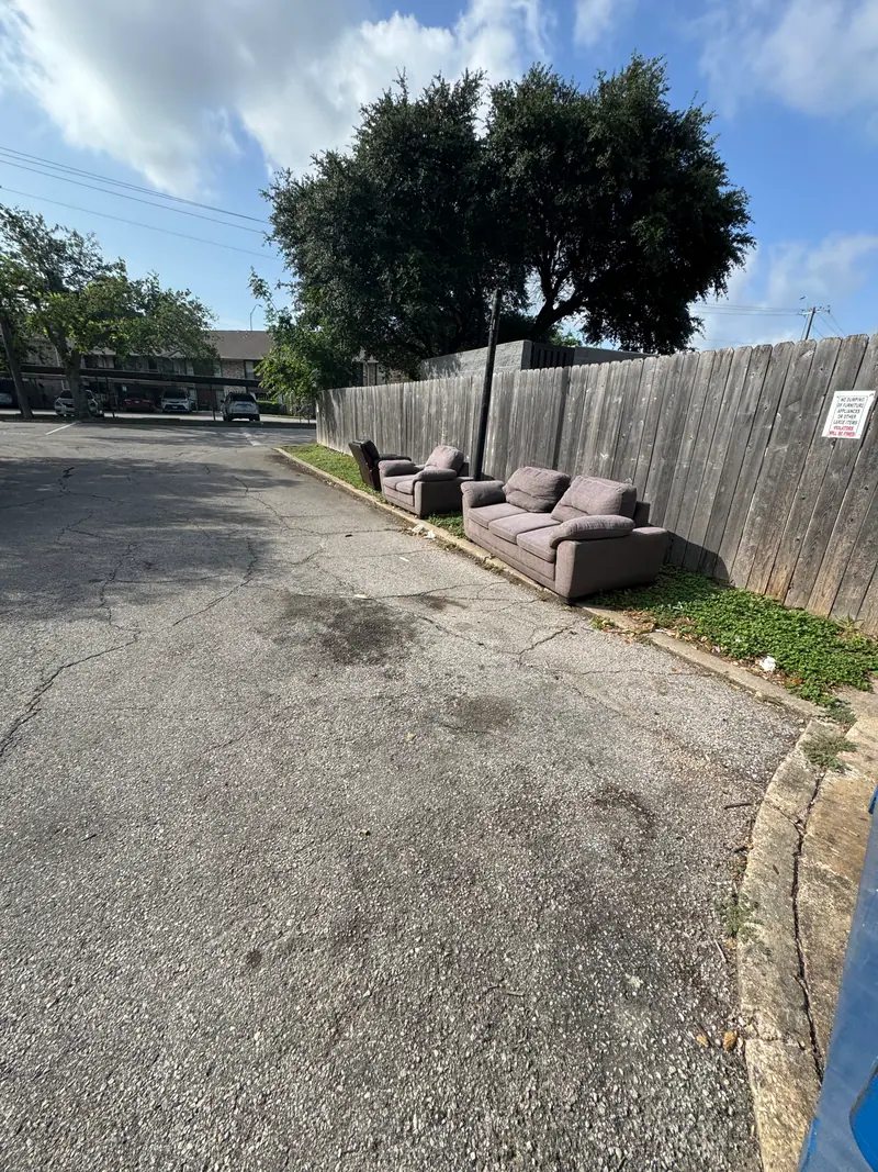 Two couches set out at a San Marcos apartment curb for furniture removal