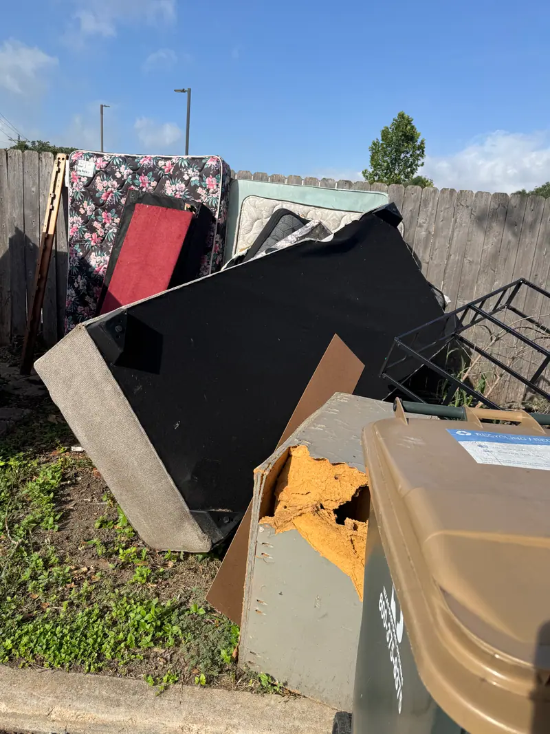 Curbside pile of mattresses, box springs and a TV panel at a San Marcos apartment